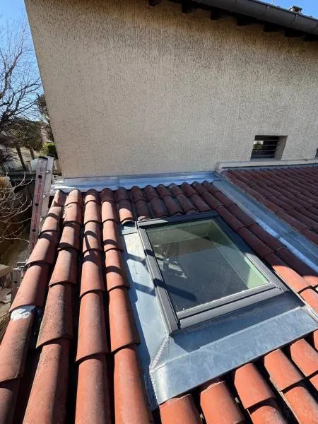 Fenêtre de toit intégrée dans une couverture en tuiles avec ses raccords d’étanchéité