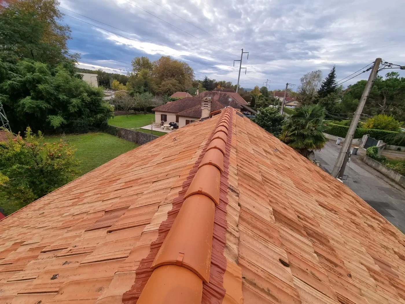 Ligne de faîtage en tuiles terre cuite vue depuis le haut de la toiture